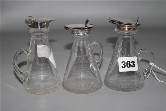 Three silver mounted glass whisky tot jugs including a pair by Wilmot Manufacturing Co, Birmingham, 1924, 4.25in.